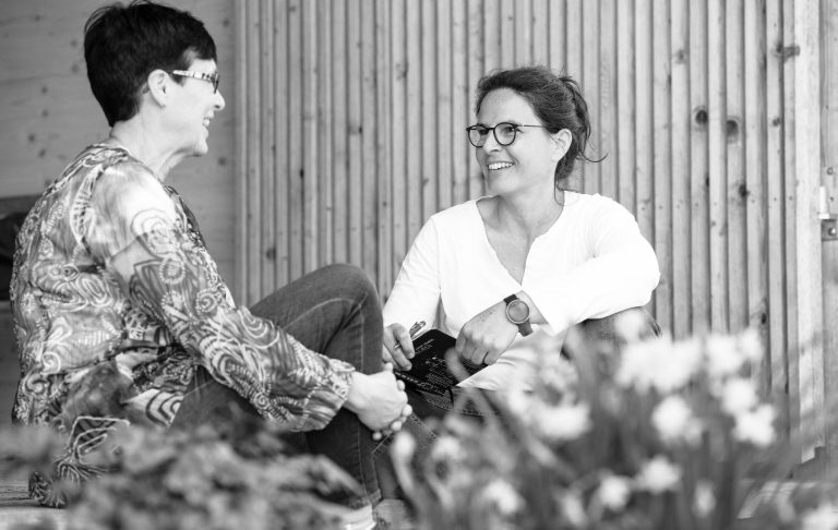 Einzelcoaching mit Tanja Hier sitzen sich Coachee und Tanja gegenüber und sind im Gespräch vertieft. Bild in Graustufen.